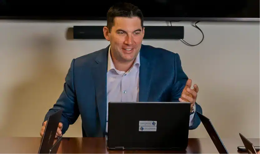 Company executive presenting ideas during an engaging meeting using a laptop with branded stickers