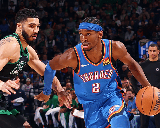 Basketball player from Oklahoma City Thunder driving toward the basket while guarded by Celtics player