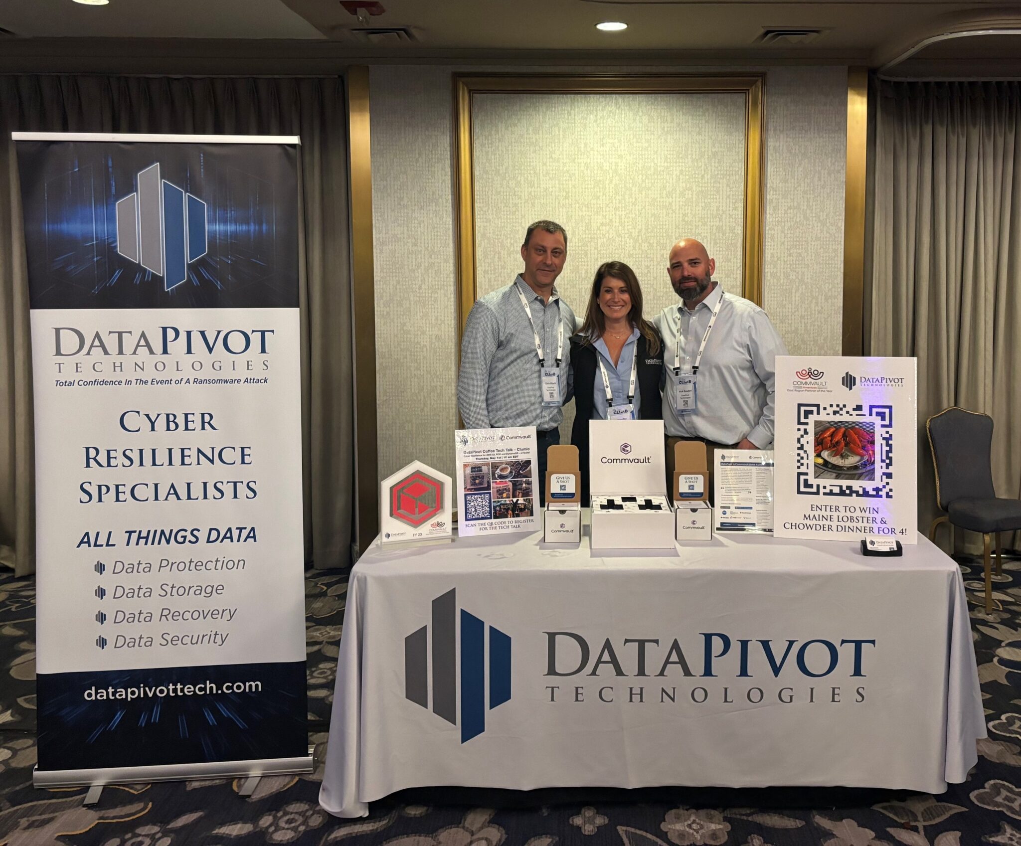 DataPivot Technologies representatives hosting a booth at a tech conference with marketing materials