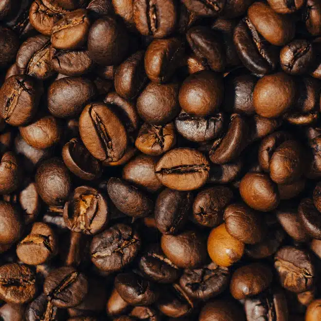 Close-up photo of roasted coffee beans showcasing a rich, aromatic texture and dark brown color