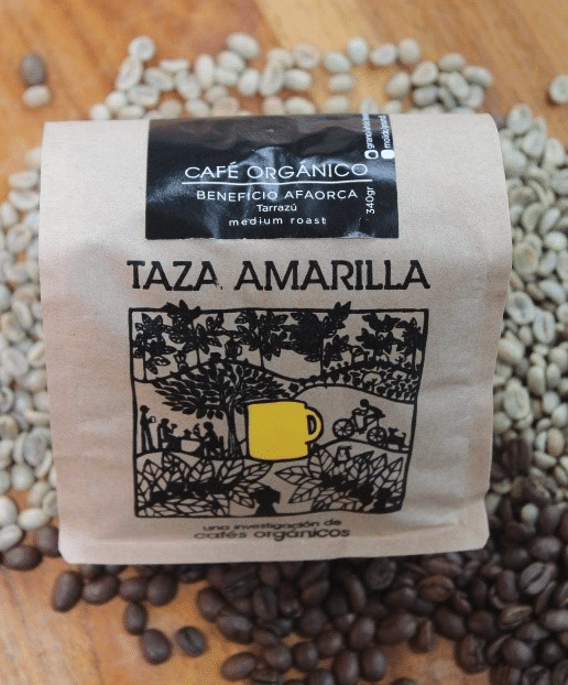 Taza Amarilla medium roast organic coffee package surrounded by roasted and green coffee beans